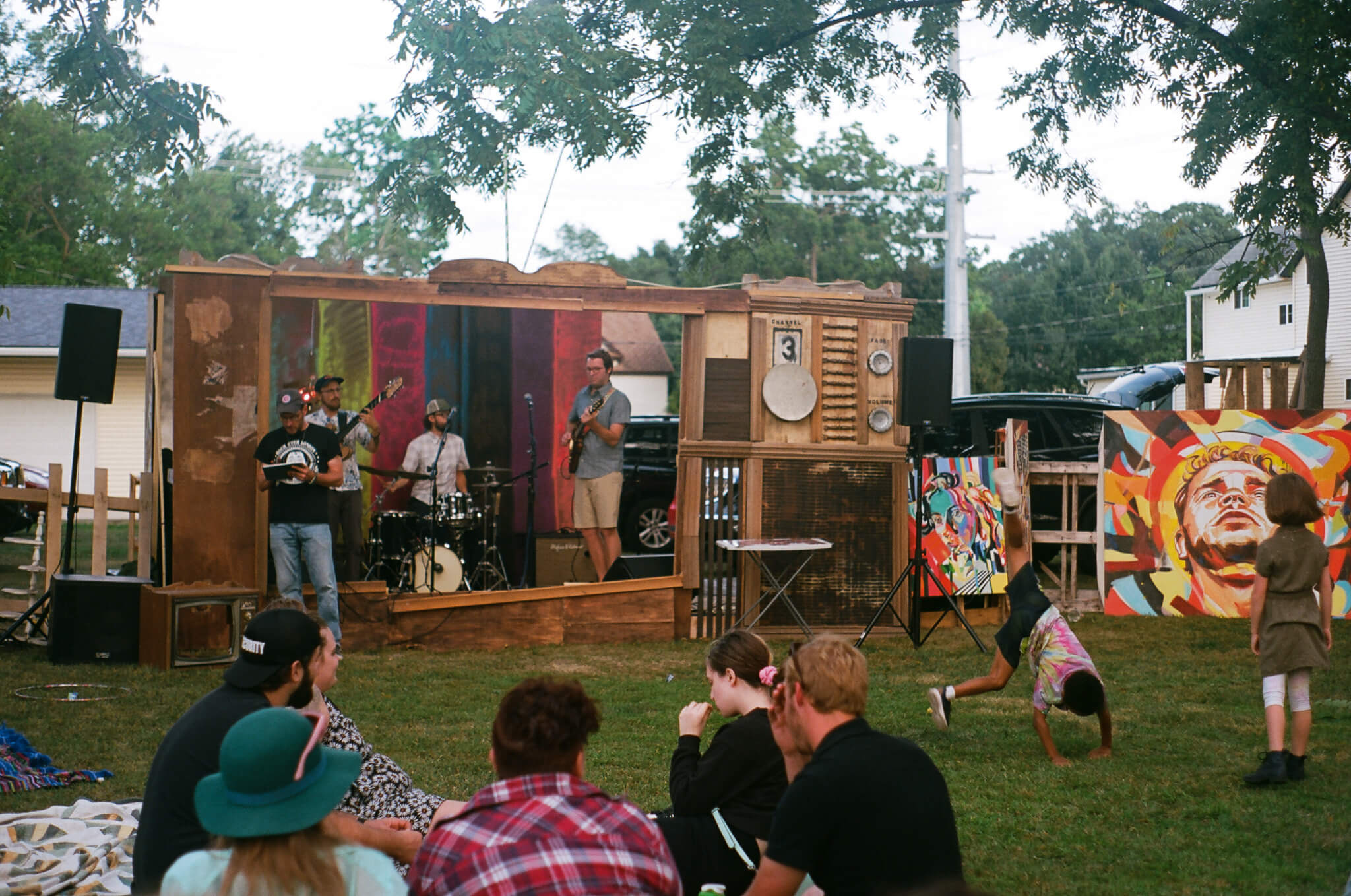 AIRIAR, a band comprising Eli Kahn, Tom Nania, Arthur Schroeder, performs inside the TV set built by Lauren Steinhofer and Jay Jeffcoat while kids do cartwheels.